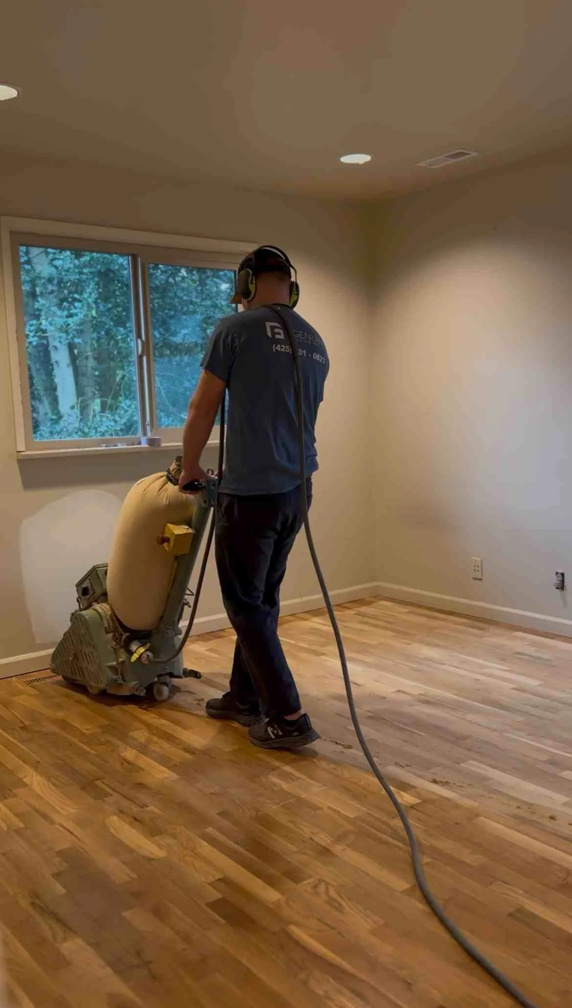 Hardwood floor sanding with industrial drum sander equipment in residential room Hardwood floor sanding with industrial drum sander equipment in residential room