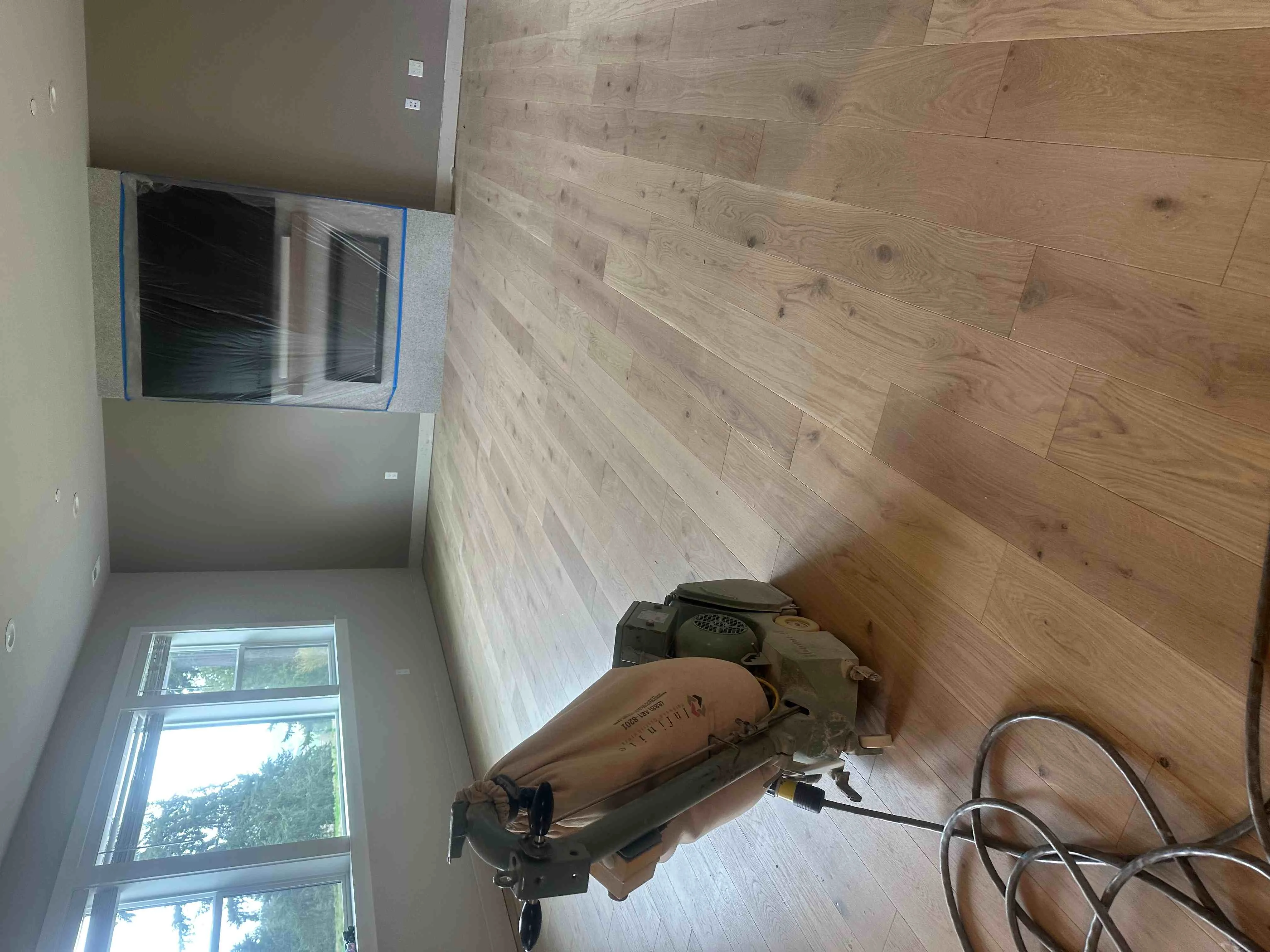 Light oak hardwood flooring installation with staggered plank layout in residential room Light oak hardwood flooring installation with staggered plank layout in residential room