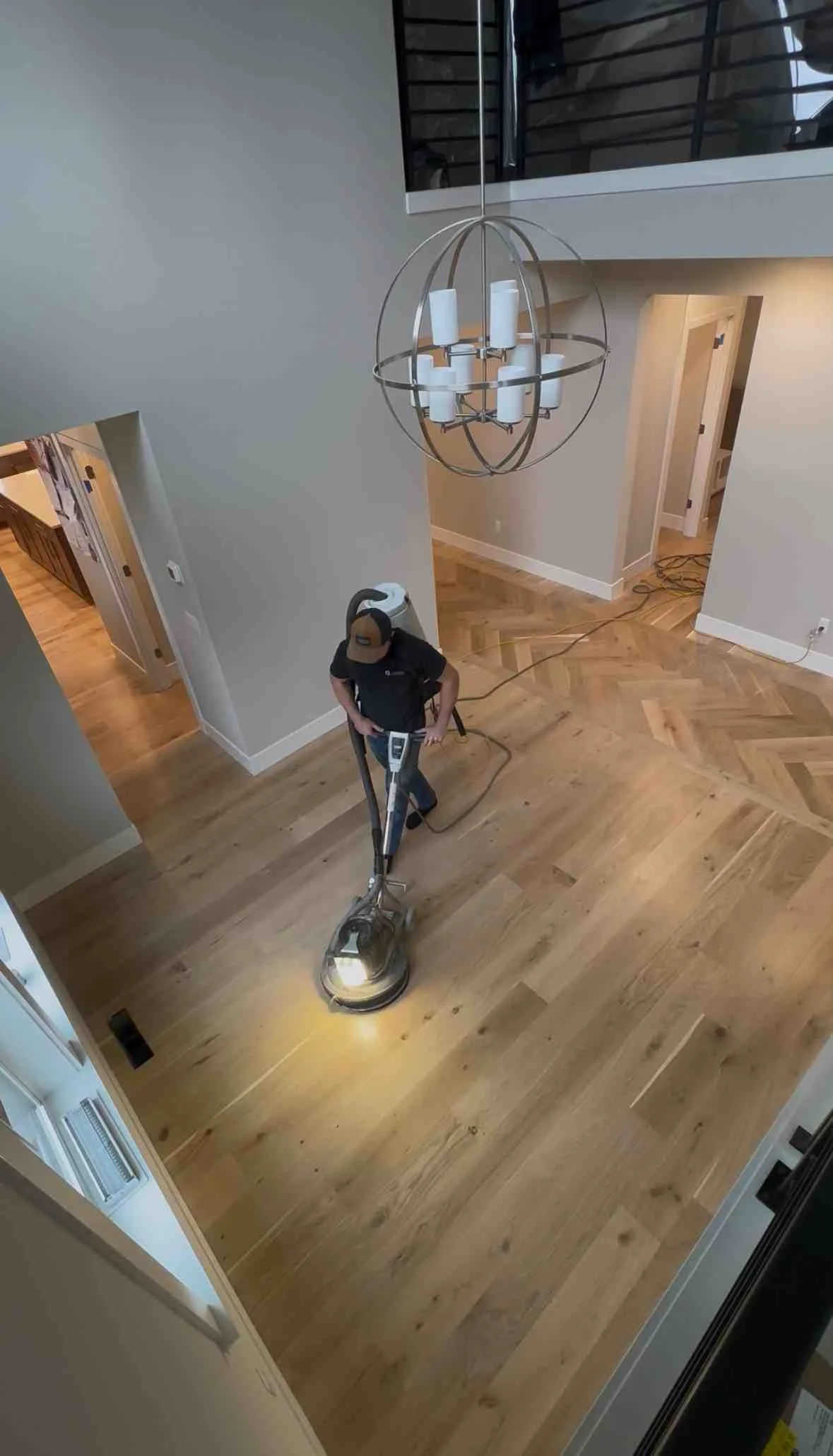Light oak hardwood flooring in herringbone pattern with professional finishing and drywall trim Light oak hardwood flooring in herringbone pattern with professional finishing and drywall trim