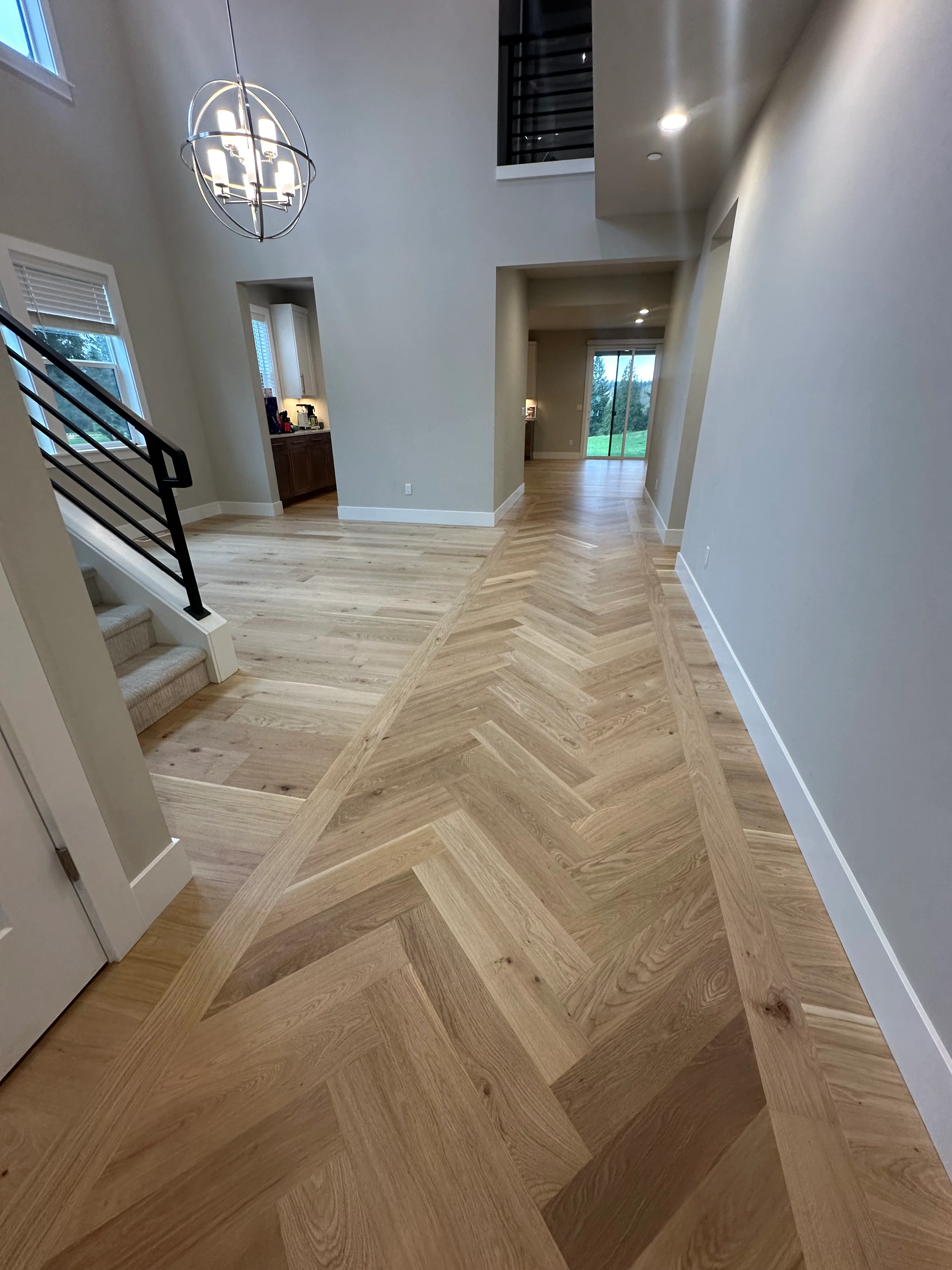 Herringbone pattern hardwood flooring in light oak throughout modern entryway and hallway Herringbone pattern hardwood flooring in light oak throughout modern entryway and hallway